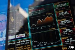 Grafik televisi terlihat di jendela kantor pusat Nasdaq di Times Square, saat Nasdaq anjlok hampir 4 persen pada 27 Januari 2025 di New York City. (Foto: AFP)