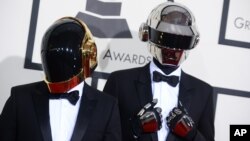 法国电音二人组合“蠢朋克”戴着机器人头盔面具抵达洛杉矶第56届格莱美奖颁奖典礼会场。(2014年2月26日)