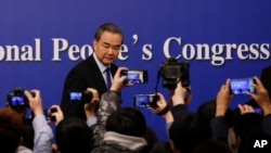 2018年3月8日中国人大会议期间,中国外交部长王毅在北京新闻中心举行记者招待会后, 记者纷纷拍摄。