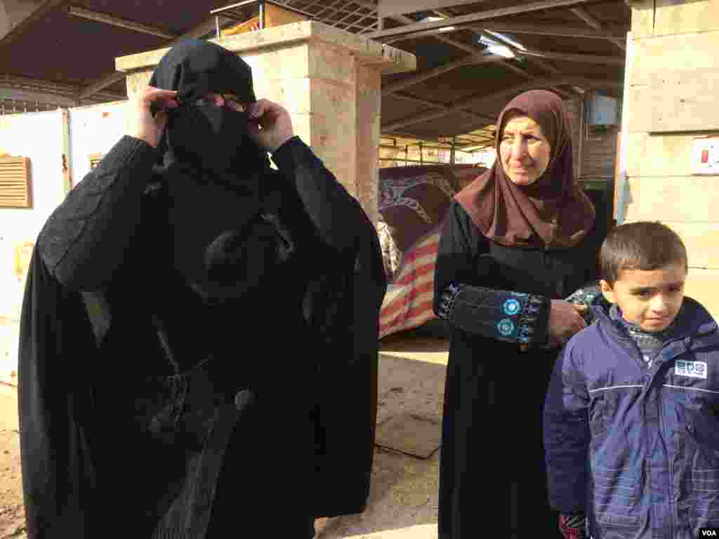 2017年1月23日,摩苏尔居民达丽娅用黑纱遮住自己的脸,向记者展示在“伊斯兰国”统治下的穿戴方式。(美国之音希瑟·默多克拍摄)  
