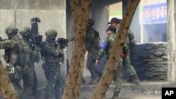 视频截图显示,2022年1月6日,在南部城市高雄进行城市巷战演练的台湾士兵准备进入一栋建筑物。(美联社)