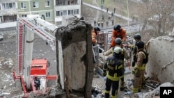 乌克兰紧急情况服务部提供的照片显示,搜救人员在乌克兰苏梅被俄罗斯无人机击中的一座公寓楼废墟寻找遇难平民。(2025年1月30日)