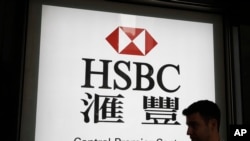 资料照:香港汇丰银行标志前一路人走过。