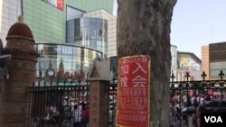 属于中国官方天主教爱国会系统的天津西开总堂在庭院内贴出的招收新教徒的学习班通知,院外是喧嚣的商业区。(2017年资料照)