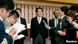 日本首相安倍晋三(中)在参拜东京靖国神社后与媒体见面。(2013年12月26日)