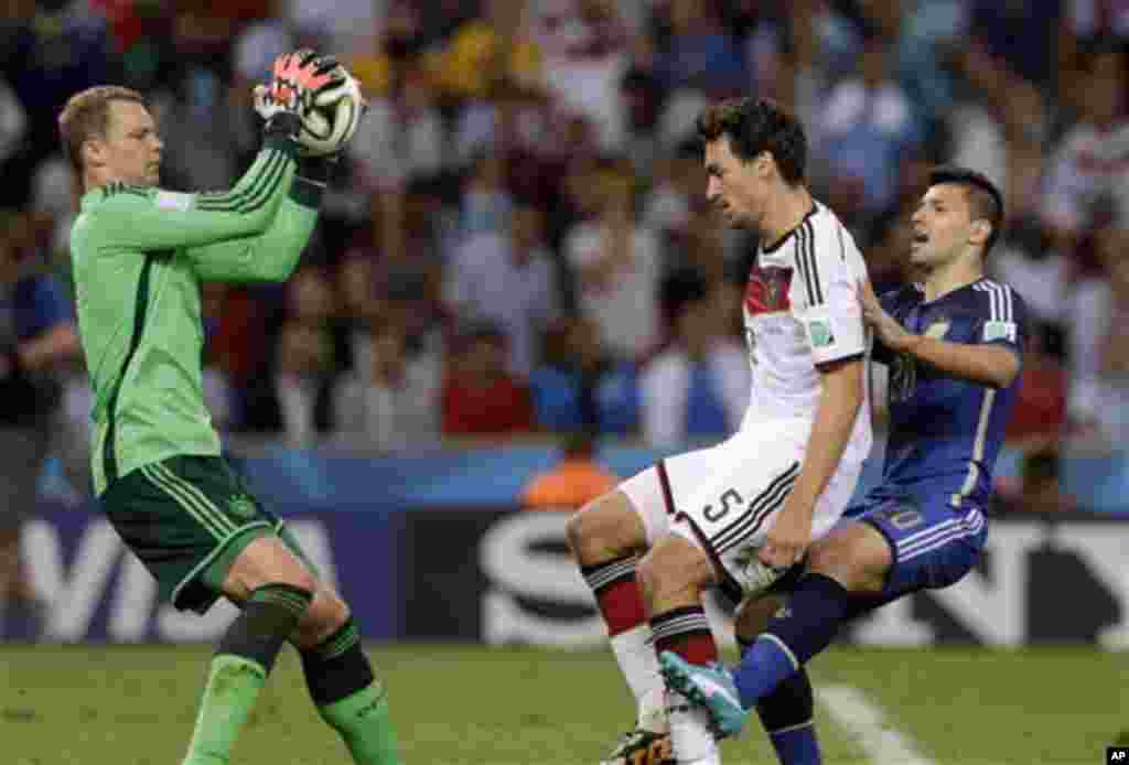 Germany's goalkeeper Manuel Neuer, left, makes a save as Germany's Mats Hummels and Argentina's Sergio Aguero, right, look on during the World Cup final soccer match between Germany and Argentina at the Maracana Stadium in Rio de Janeiro, Brazil, Sunday,
