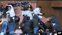 资料照片:国民党立法委员试图闯入台湾立法院时,民进党立委用椅子挡住入口。(2024年12月20日)