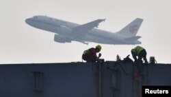 四川成都展览中心建筑工地上空飞过的中国国航飞机。(2020年2月26日)