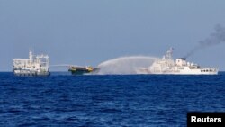 中国海警船向前往南中国海第二托马斯浅滩执行补给任务的菲律宾补给船发射水炮。(2024年5月4日,路透社)