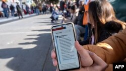 Seorang imigran pencari suaka ke AS di perbatasan Meksiko menunjukkan pesan terbaru di aplikasi CBP One yang menyebutkan bahwa semua janji temu telah dibatalkan hari Senin (20/1).