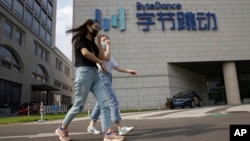 两名女子从位于北京的TikTok母公司字节跳动的总部旁走过。(2020年8月7日)
