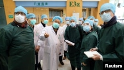 资料照:新冠疫情在武汉爆发初期,世卫组织与中国的医学专家们视察武汉同济医院。(2020年2月23日)