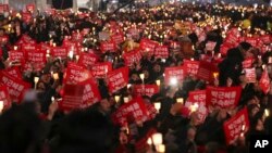 Những người biểu tình giơ cao những cây nến tại Gwanghwamun, cổng chính của cung điện Gyeongbok, một trong những địa danh nổi tiếng của Hàn Quốc, trong một cuộc biểu tình kêu gọi Tổng thống Park Geun-hye từ chức.