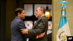 美国国务卿马尔科·卢比奥(左)2025年2月5日在危地马拉城文化宫举行的联合新闻发布会上与危地马拉总统贝尔纳多·阿雷瓦洛交谈。