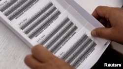 资料照：2023年11月16日，一名工人在山东平度市梦雪莉眼睫毛加工厂生产假睫毛的生产线上工作。(路透社）