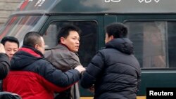 Ông Trương Tuyết Trung, luật sư của ông Triệu Thường Thanh từ chối đưa giấy tờ chứng minh cho cảnh sát mặc thường phục khi ông bị họ chận lại trên đường đến tòa án để dự phiên tòa xử ông Triệu ở Bắc Kinh, 23/1/14