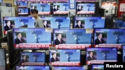 首尔的一名店员观看电视屏幕上有关朝鲜核试验的消息。(2016年1月6日)