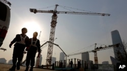 建筑工人从北京市中心商业区的一个建筑工地走出 (2015年1月20日)