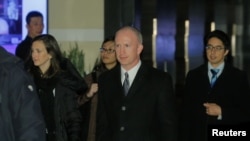 美国副贸易代表格里什(中)一行2019年1月7日离开北京的一家酒店(路透社)