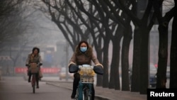 北京雾霾笼罩,行人上街带着口罩。(资料照片)