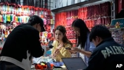 China Singles Day2024 年 11 月 8 日星期五,商家在位于中国东部浙江省义乌市的义乌批发市场内的商店里拍摄珠宝产品以供电子商务销售。