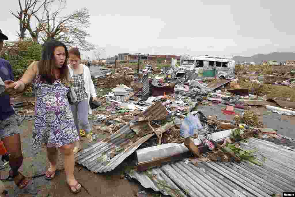 Một phụ nữ mang thai đi qua đống đổ nát sau Siêu bão Haiyan tại thành phố Tacloban, miền trung Philippines, ngày 9/11/2013.