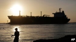 美国德克萨斯州海岸边一艘油轮驶过一名垂钓者驶向科珀斯·克里斯蒂港。(资料照片)