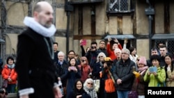 游客在莎士比亚故乡、英格兰埃文河畔斯特拉福镇观赏艺术家为纪念莎士比亚逝世400周年而表演的莎剧。 （2016年4月23日）