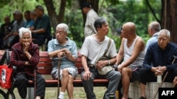 中国安徽省阜阳市的老人坐在一个公园的长椅上。(2024年9月13日)