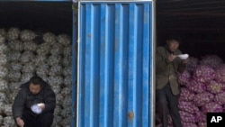 中国10月通胀率创25个月新高。在北京的一个蔬菜批发市场,蒜农一边吃午饭,一边等买主。