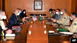 In this photo released by Pakistan's military, a U.S. delegation headed by peace envoy for Afghanistan, Zalmay Khalilzad, third left, hold talks with Pakistan's army chief, Gen. Qamar Javed Bajwa, second right, in Rawalpindi, Sept. 14, 2020.