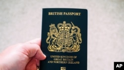 资料照片:一人手持的英国护照。