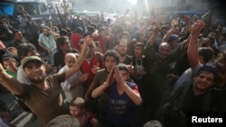 Phiến quân và người dân mang cờ Quân đội Tự do Syria và Jabhat Fatah al-Sham khi họ ăn mừng tin phá quyền kiểm soát của chính phủ ở Aleppo, Syria, ngày 6 tháng 8 năm 2016.