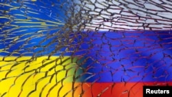 资料照片:2022年3月1日拍摄的照片中,透过破碎的玻璃可以看到乌克兰和俄罗斯国旗。(路透社照片)