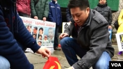 乌坎村民庄烈红在纽约联合国大楼前焚烧中共党旗(2017年2月7日,美国之音章真拍摄)