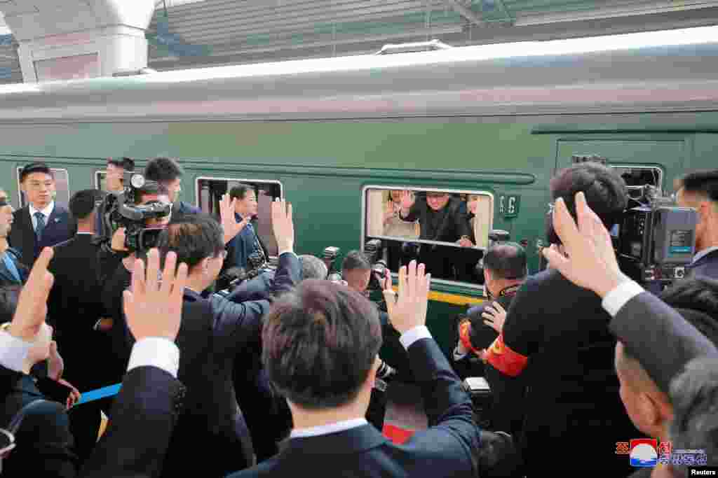 North Korean leader Kim Jong Un waves from a train, as he pays an unofficial visit to China, in this undated photo released by North Korea's Korean Central News Agency (KCNA) in Pyongyang, March 28, 2018.