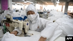 在温州一家工厂，工人们正在缝制防护服。（2020年2月28日）