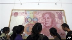 参观者在成都的展览会上观看人民币百元钞票（2011年10月）