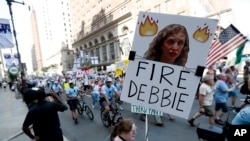 桑德斯参议员的支持者举着要求罢免美国民主党全国委员会主席黛比·舒尔茨的标语牌(2016年7月24日)