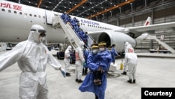 台湾防化兵在对从武汉飞抵桃园机场包机的台湾人进行防疫消毒作业。(图片来源:台湾国防部军闻社)