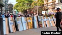 在缅甸仰光,抗议者搭起盾构,为可能的冲突做准备。