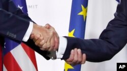 美国总统特朗普和法国总统马克龙在七国集团峰会的新闻发布会上握手(2019年8月26日)。