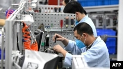 上海生产医疗设备的西门子工厂工人戴着口罩在生产线上工作。(2020年2月24日)