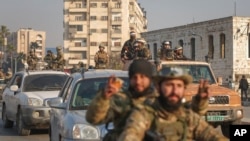 叙利亚反政府武装占领中部城市哈马,战士们在街上巡逻。(美联社:2024年12月6日)