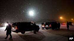 奥巴马总统的车队在雪中准备离开安德鲁斯空军基地跑道前往华盛顿。(2016年1月20日)