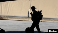 资料照片:一名美国陆军军人在巴格达以北的塔吉基地参加将基地控制权从联军移交给伊拉克安全部队的仪式。(2020年8月23日)