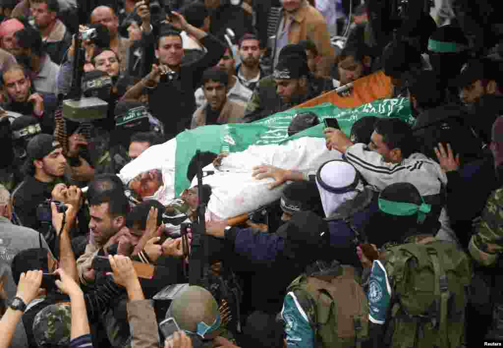 2012年11月22日,哈马斯激进分子在加沙地带中部举行的葬礼中抬着战友的尸体。医疗救护人员说,他们11月22日死于以色列空袭。