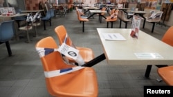 2022 年 1 月 7 日,香港为遏制新冠病毒传播采取更严格的限制措施后,因为餐厅食肆关闭晚上六时后的堂食生意而贴上胶带禁止使用的座位 (路透社照片)