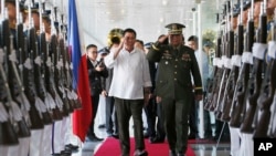 2016年10月25日,菲律宾总统杜特尔特(中左)向军队敬礼,之后他登机前往日本进行为期三天的国事访问。