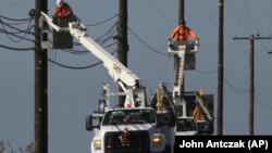 资料照:美国加州电力公司的工人政治修理电力网。